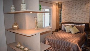 Une chambre à coucher comprenant un lit, des tables de chevet, une fenêtre et des objets décoratifs.