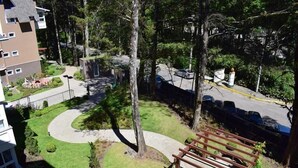 Un quartier résidentiel avec une allée sinueuse, un banc en bois et un parking où sont garées des voitures.