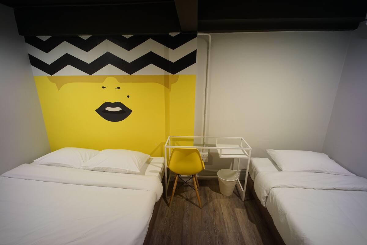 Een kamer met twee bedden, een bureau en een stoel.