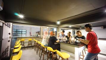 A bar area with yellow stools and a counter.