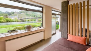 Una habitación moderna con un ventanal amplio, un sofá y un radiador.