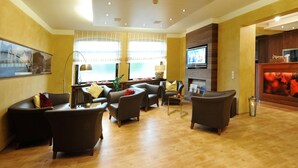 Una sala de estar moderna con chimenea, asientos cómodos y televisor.