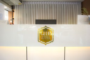 A reception desk with a sign that reads "CLUR CENTRAL PRATUNAM". - Glur Central Pratunam (Bangkok)