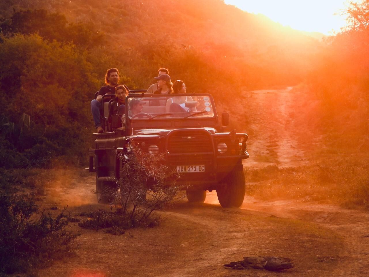 Um veículo com passageiros em uma estrada de terra.