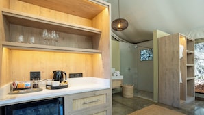 Una cocina moderna con estantes de madera, una cafetera y un refrigerador.