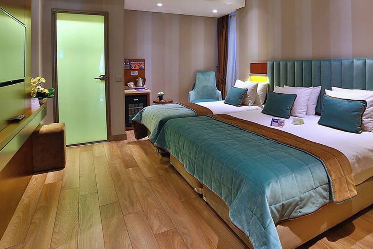 A hotel room with a large bed, bedside tables, a desk, and a chair.