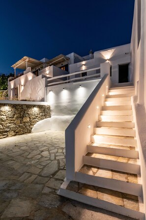 A staircase leading to a building with white walls and stone steps. - Melangel (Mykonos)