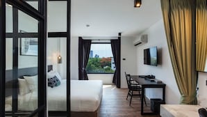 A modern hotel room with a bed, a desk, a chair, and a TV. - Oriental Heritage Hotel (Bangkok)