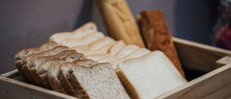 A wooden box containing slices of white and whole loaves of bread.