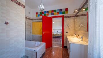 A modern bathroom with a bathtub, a sink, and a shower.