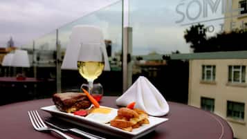A dining table with a plate of food, a glass of white wine, and a napkin.