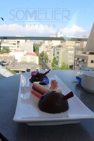 A dessert on a white plate with a cityscape view in the background.