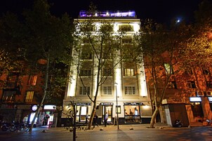A multi-story building with illuminated signage for 'Hotel Boutique' and 'Antique'.