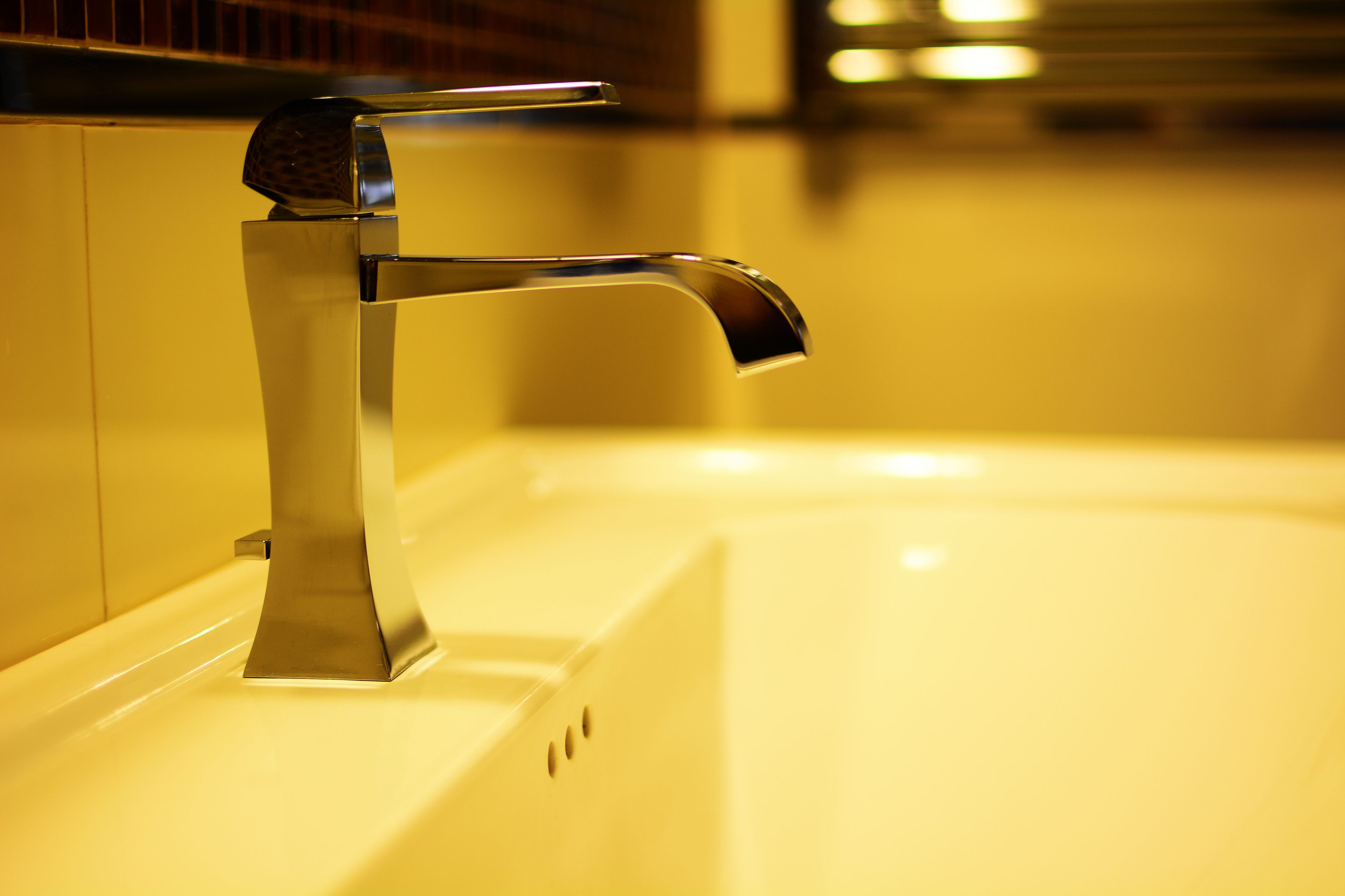 Un baño moderno con grifo de cromo y bañera blanca.