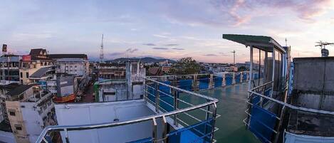 Una zona ribereña con barcos amarrados, una plataforma de observación y edificios al fondo.