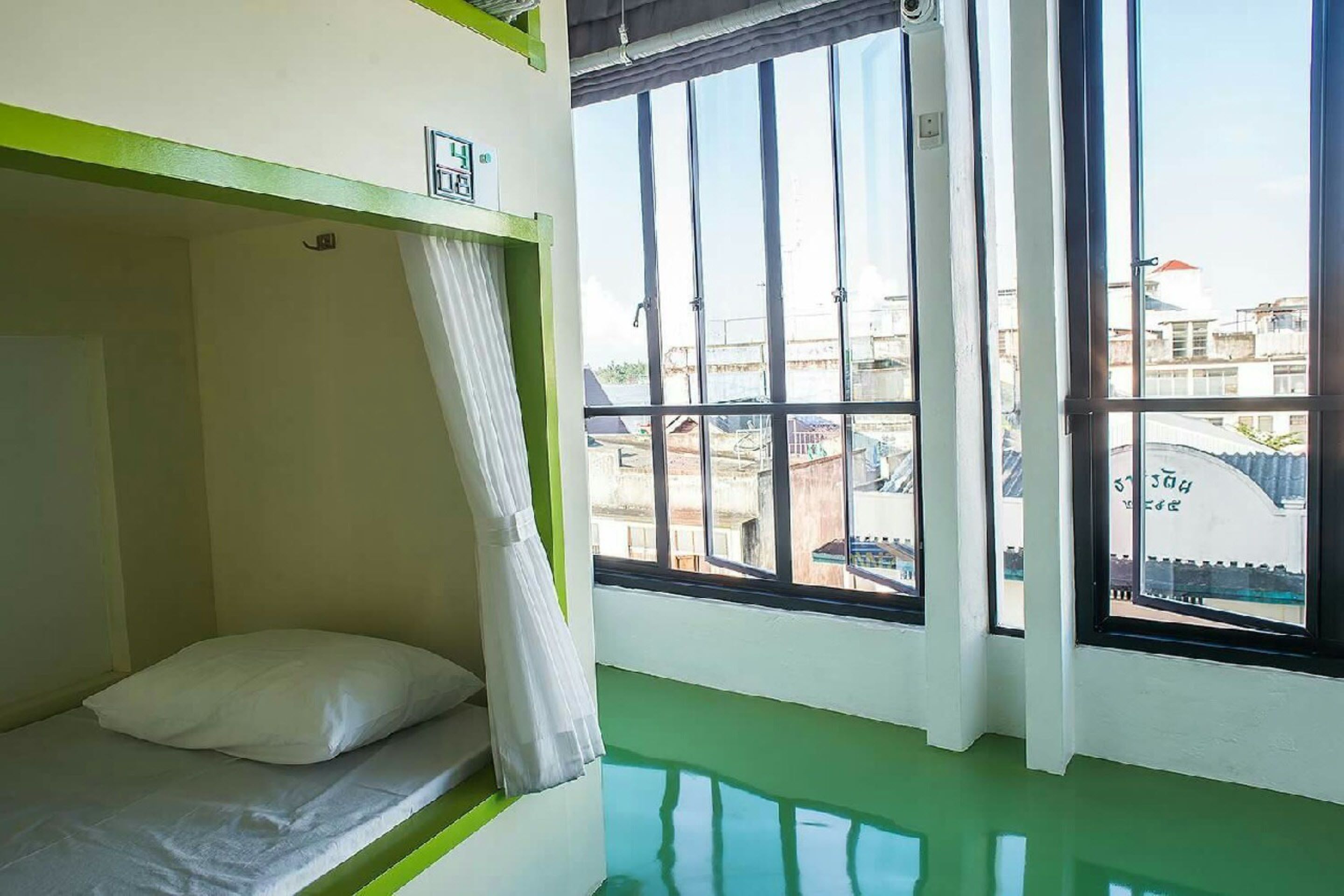 A bunk bed room with a window view of buildings.