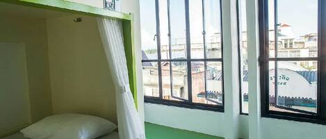 A bunk bed room with a window view of buildings.