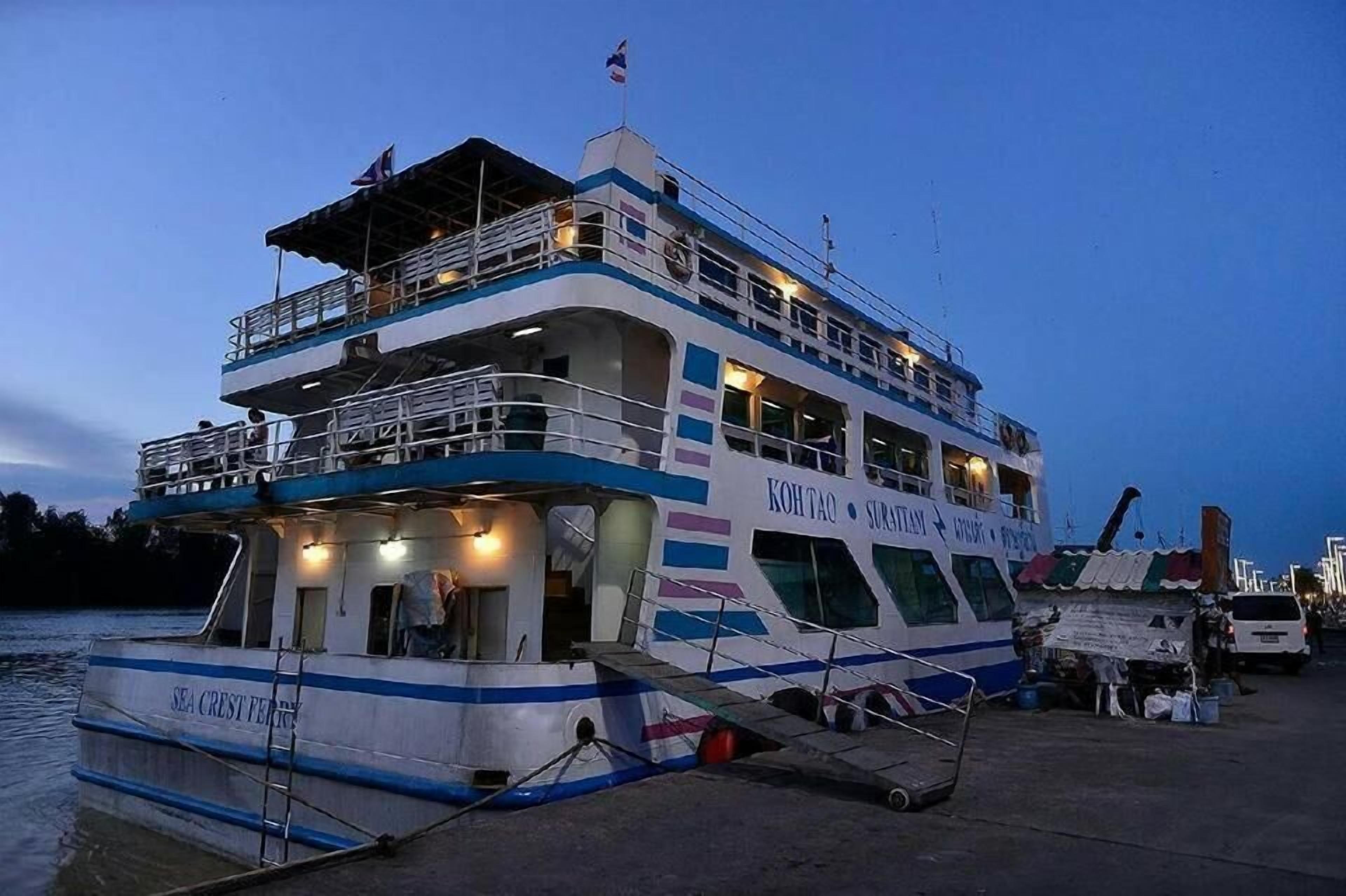 A multi-deck ferry with a name and logo on the side, docked at a pier.