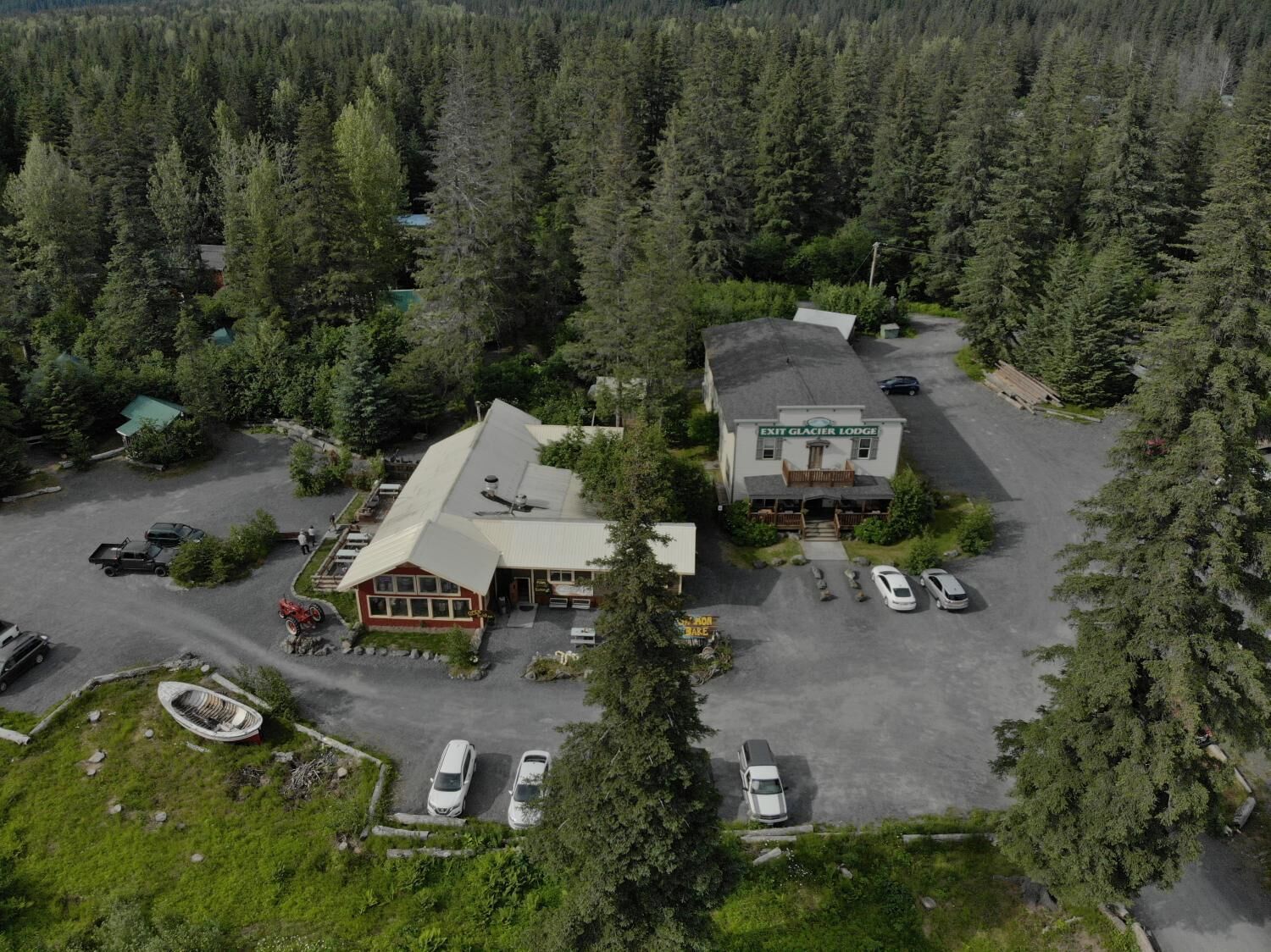 Ein Luftbild eines Lodges mit Parkplatz, umgeben von dichtem Wald.