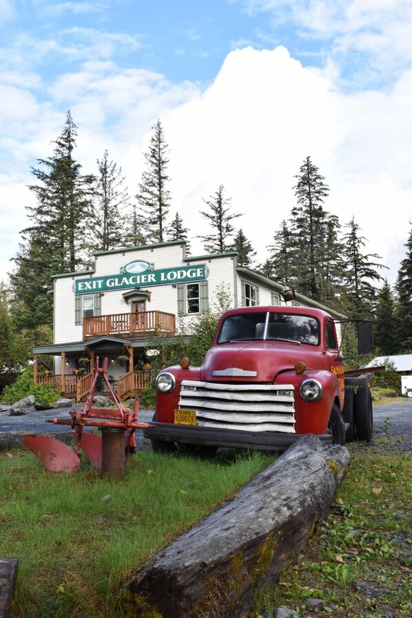 A red truck parked in front of Exit Glacier Lodge.