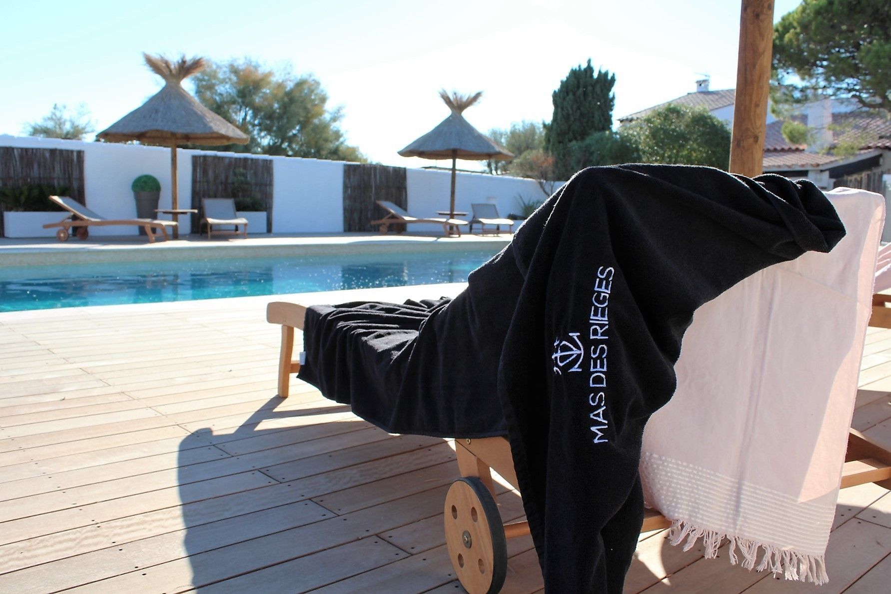 Un espace aménagé au bord de la piscine, avec des chaises longues et un coin salon abrité.