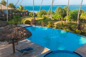 Una piscina al aire libre, tumbonas