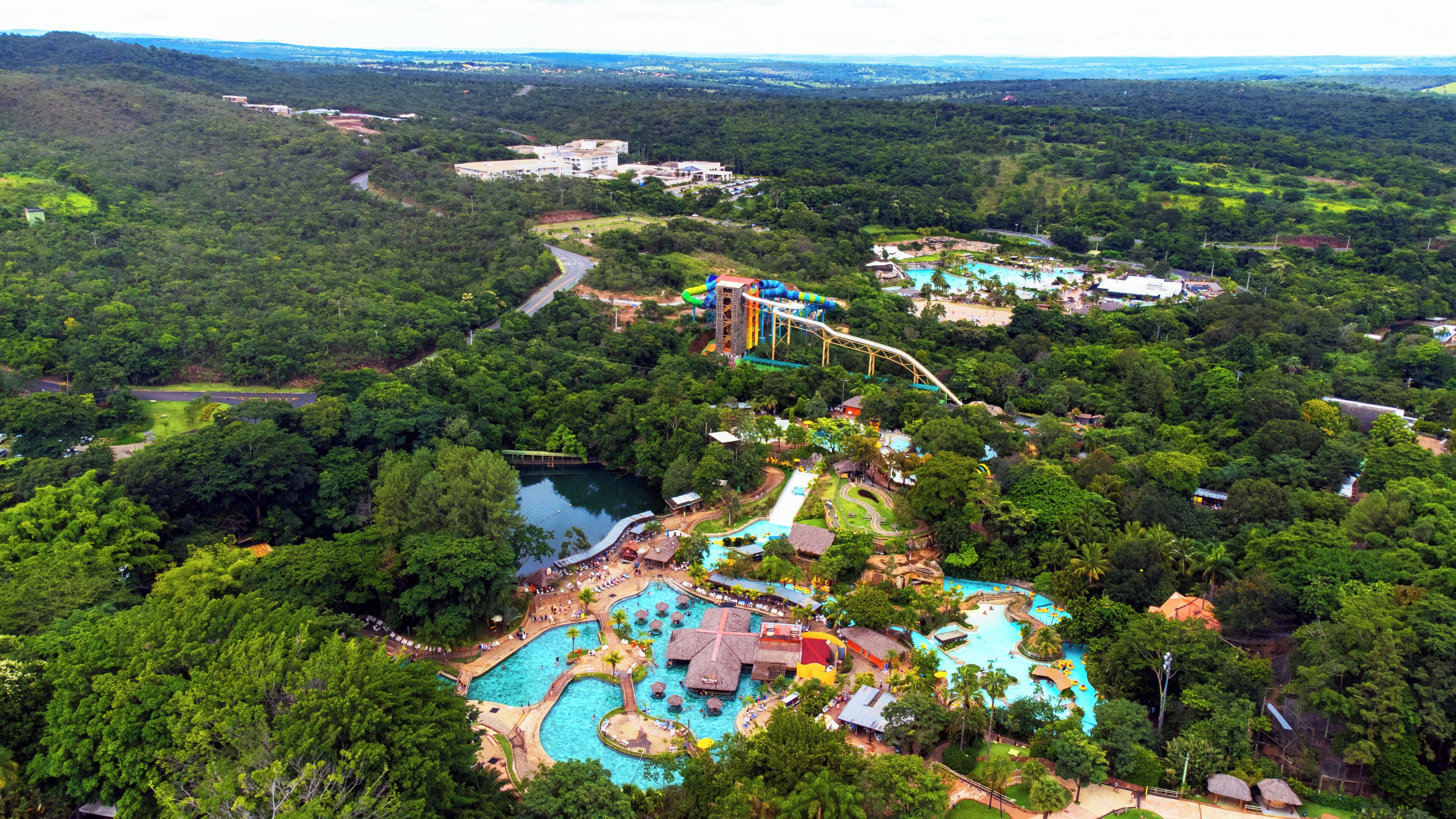 A resort with a large swimming pool, a water park, and lush greenery.