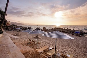 På stranden, solstolar, parasoller och strandhanddukar