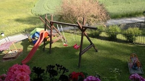 Een speelplaats met schommels en een glijbaan.