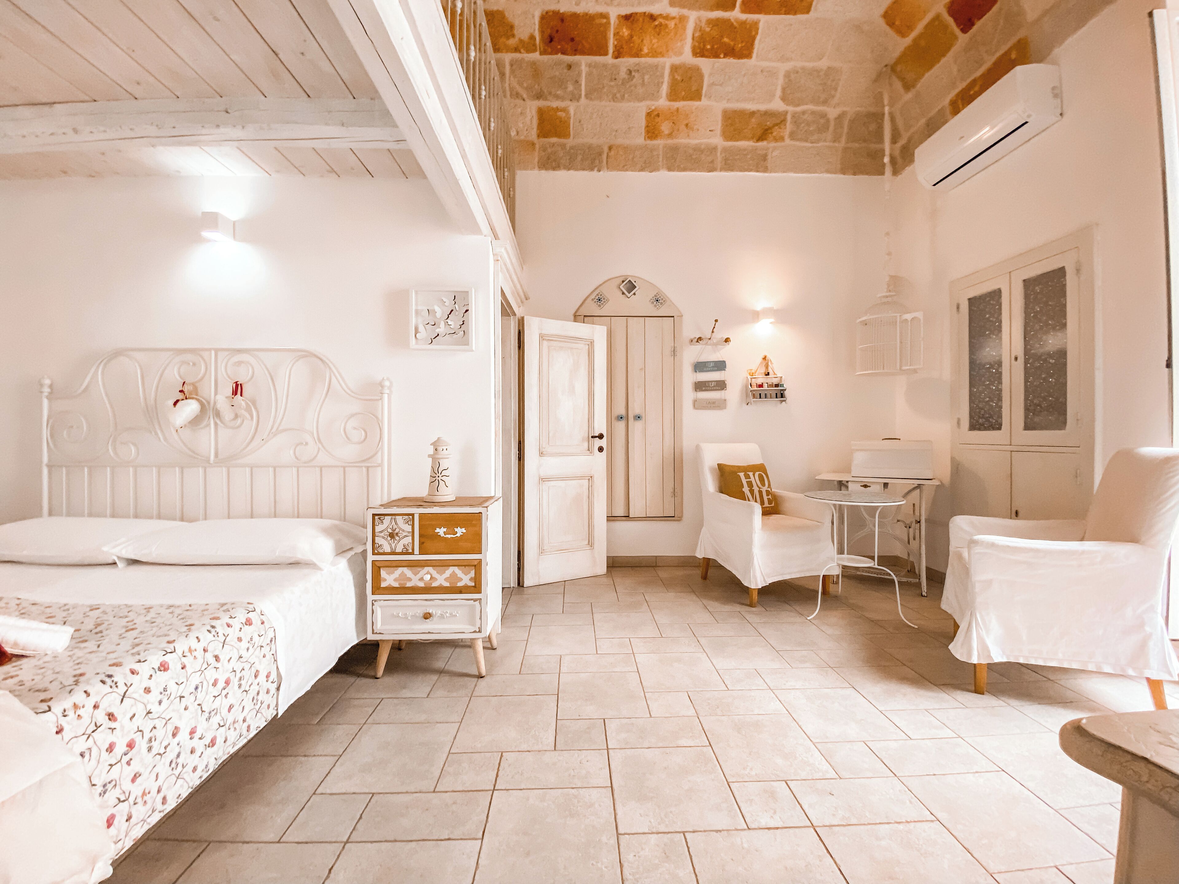 Une chambre à coucher comprenant un lit, une table de chevet, une chaise, une petite table et une armoire.