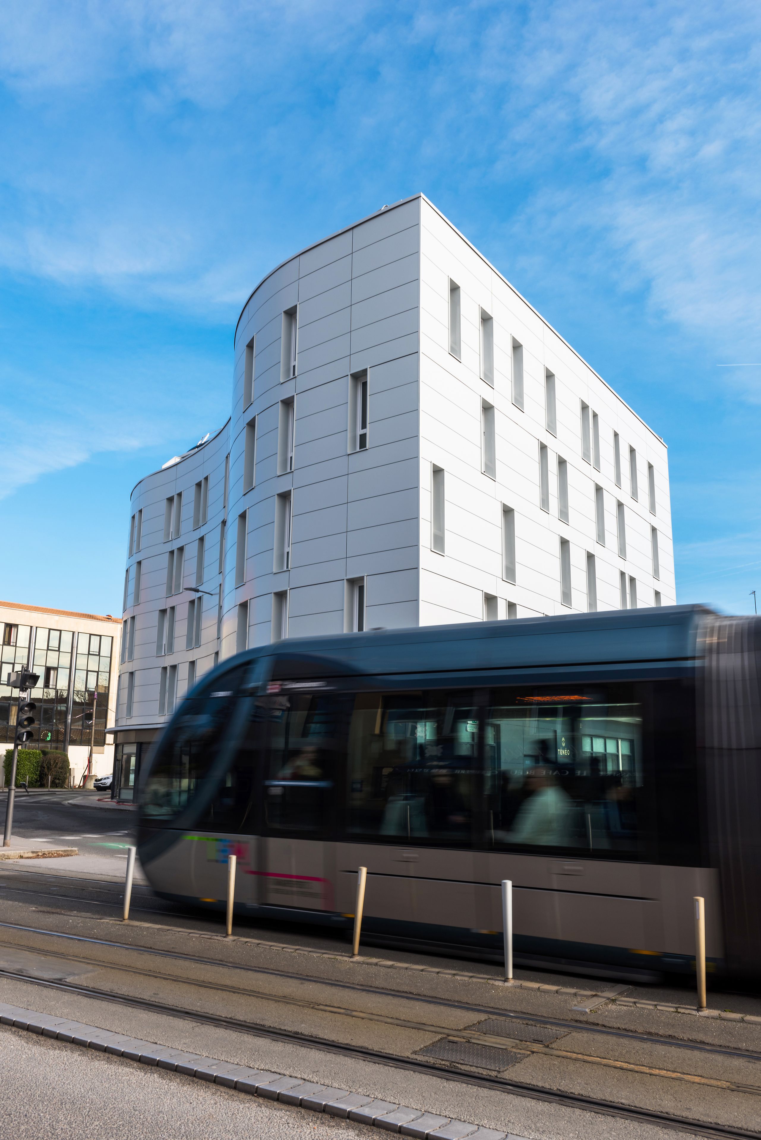A modern building with a curved facade and multiple windows.