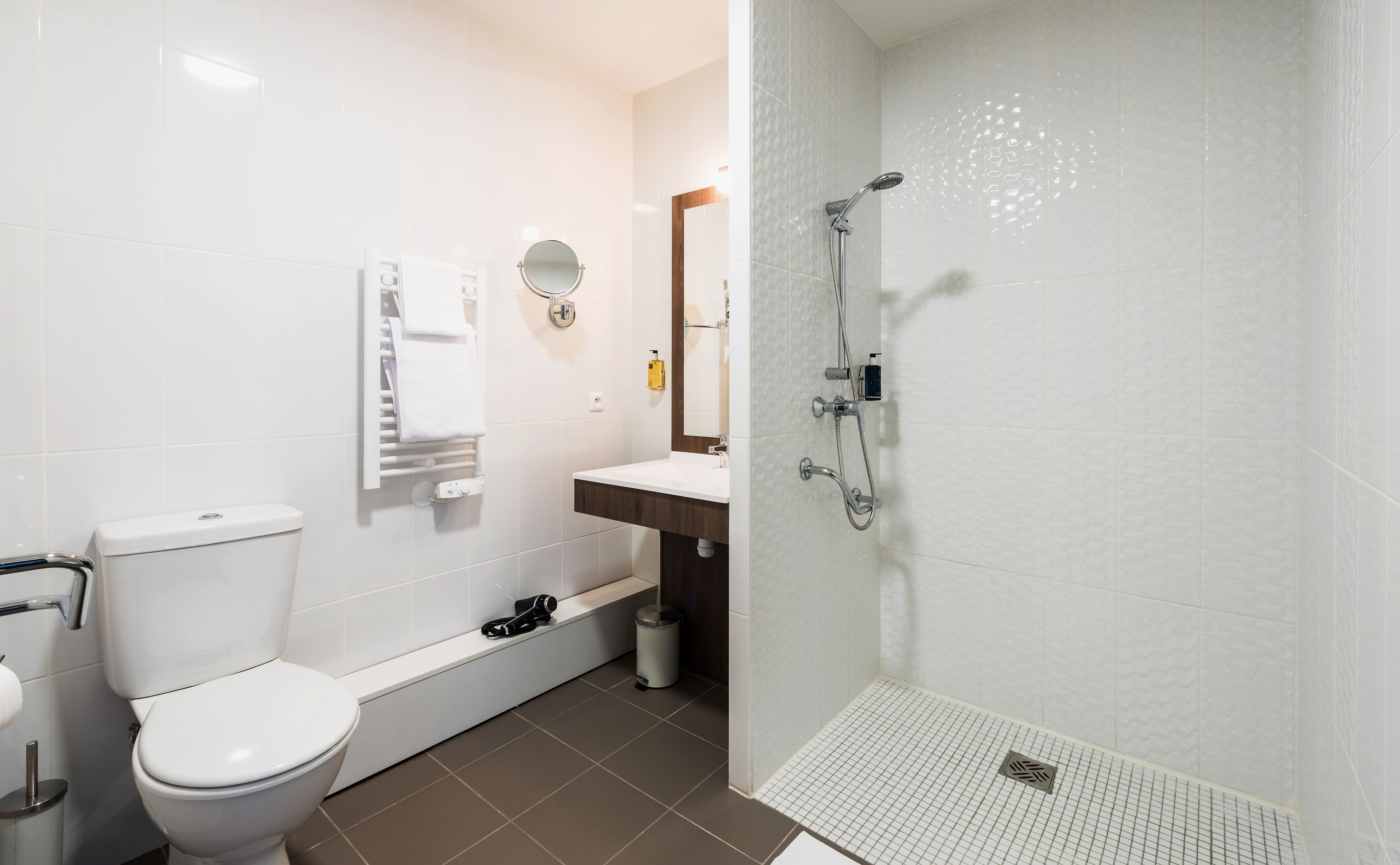A modern bathroom with a toilet, sink, and shower.