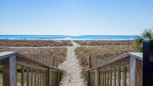 Un sendero de madera que lleva a una playa con una vista despejada del océano.