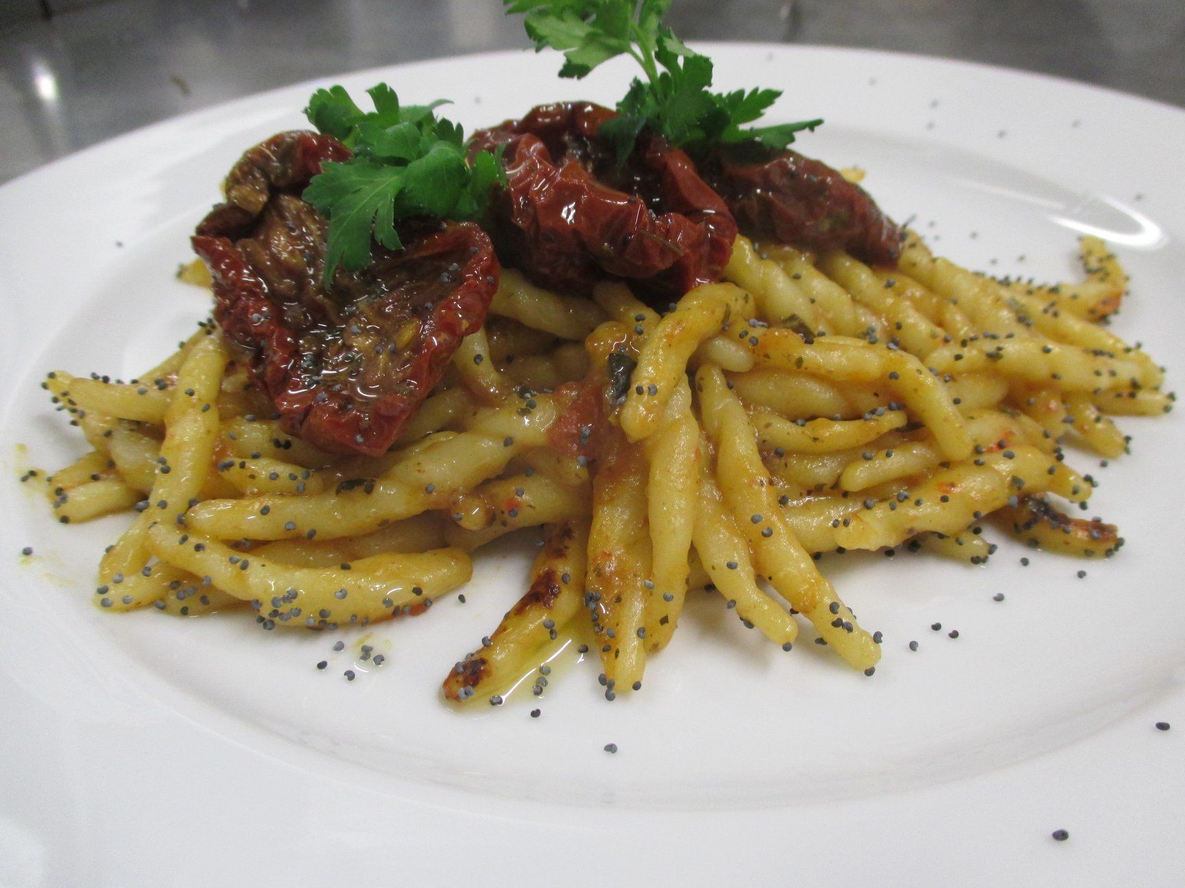 A plate of pasta with meat and a garnish of parsley.