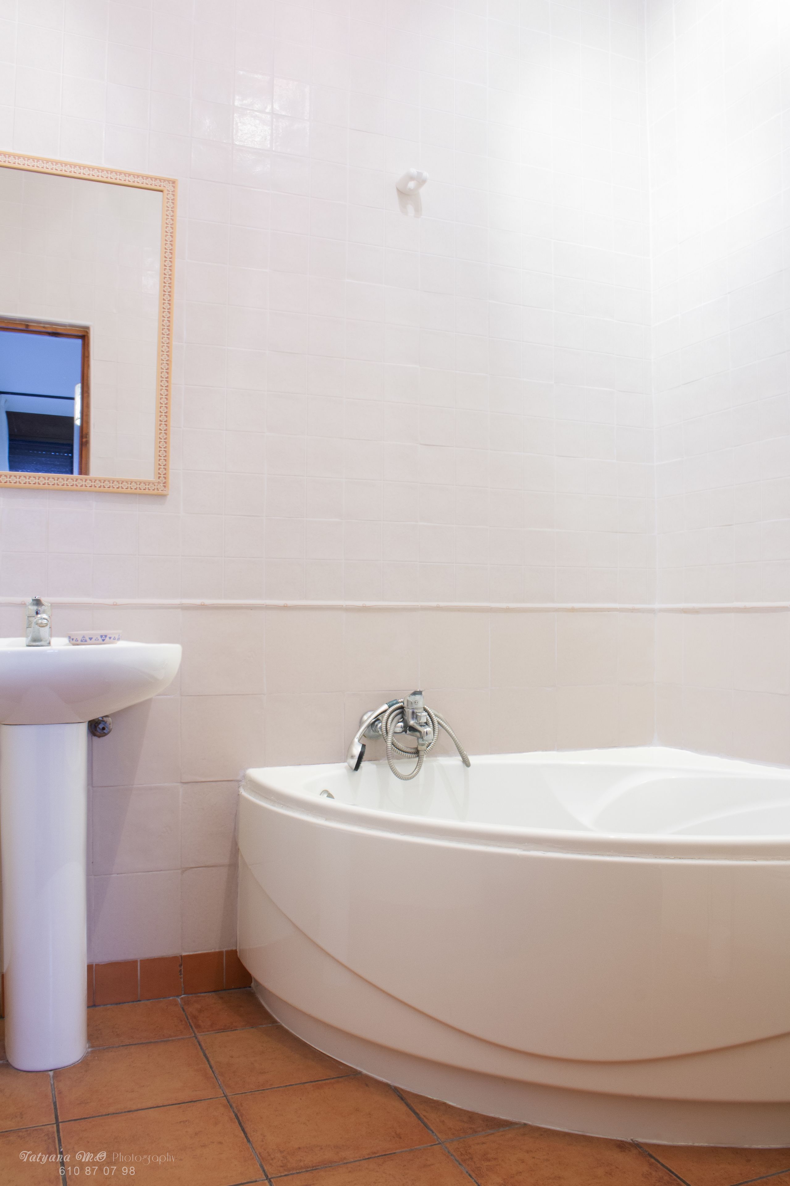 A bathroom with a white sink, a mirror, and a bathtub.