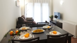 A dining area with a table set for two, featuring plates of food, wine glasses, and orange napkins. - Andorra4days Soldeu - El Tarter (Soldeu)
