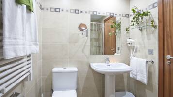 A modern bathroom with a toilet, sink, and shower.