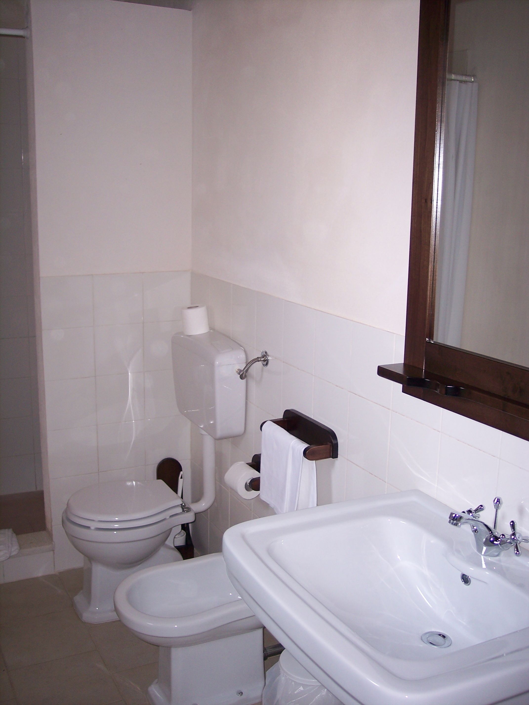 A bathroom with a toilet, bidet, and sink.