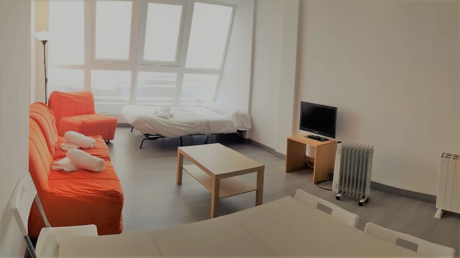 Une chambre d’hôtel moderne équipée d’un lit, d’un canapé, d’une télévision et d’un radiateur.