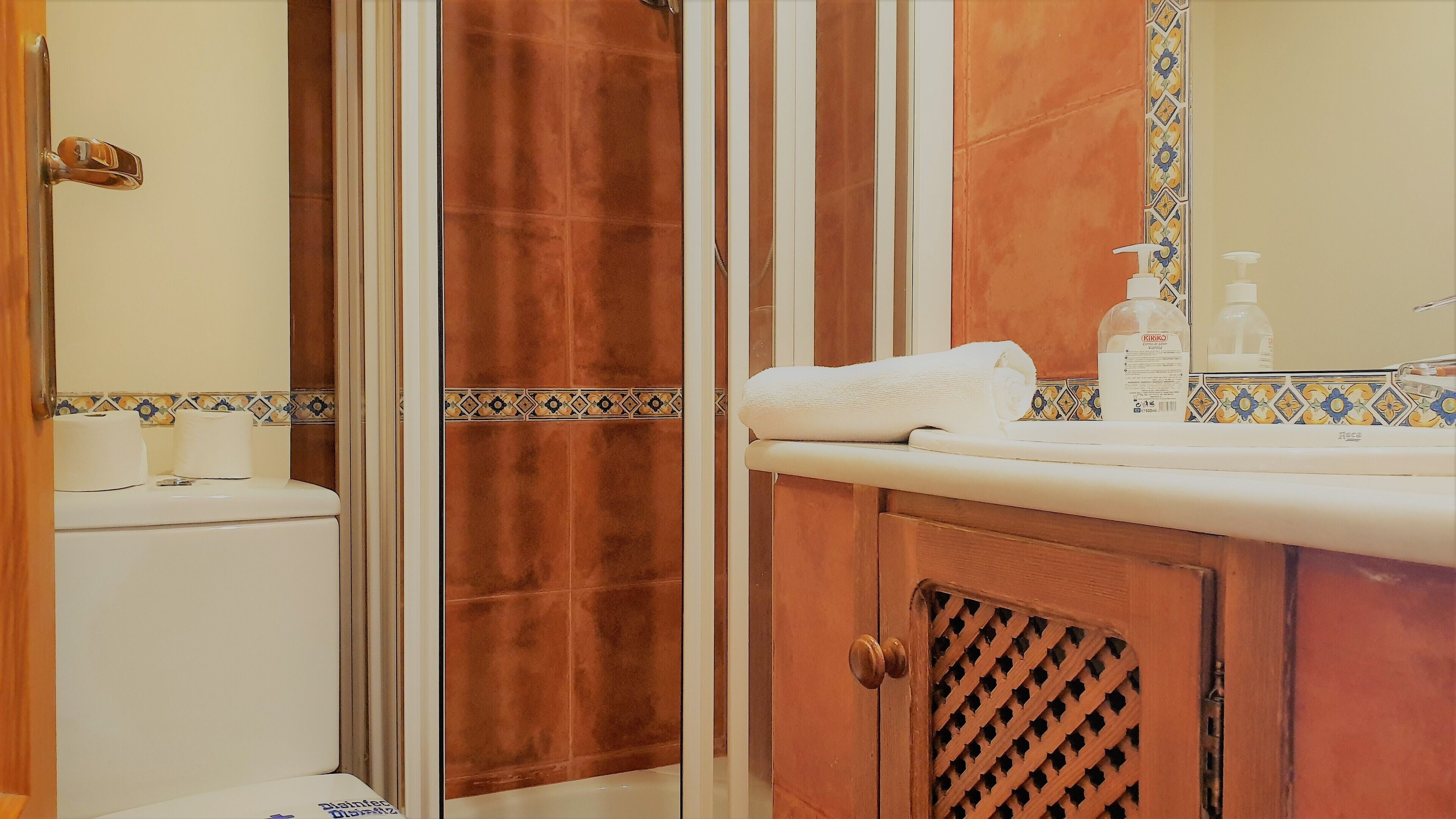 A bathroom with a shower, toilet, and sink.