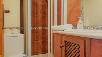 A bathroom with a shower, toilet, and sink.