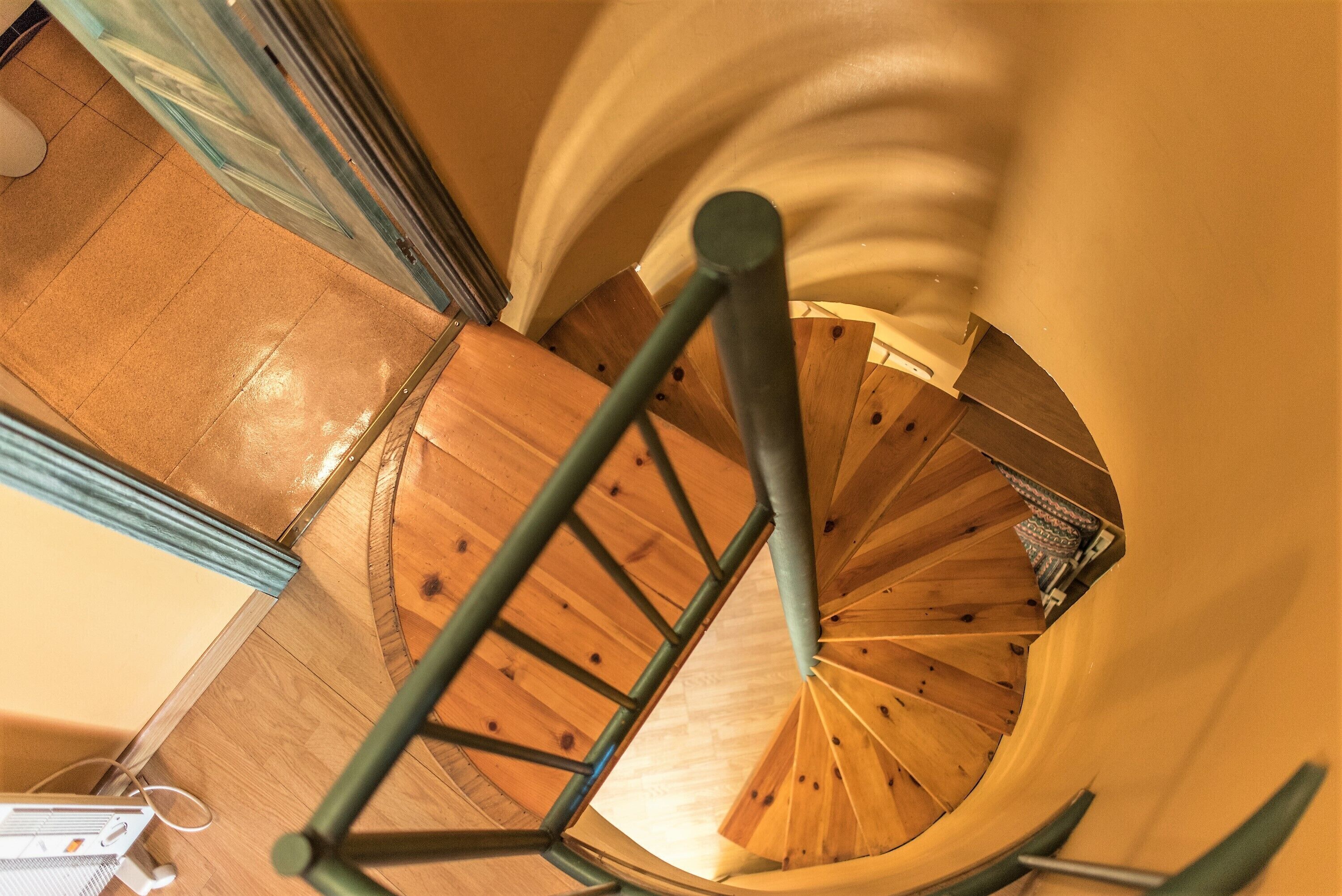 A spiral staircase with wooden steps and metal railings.