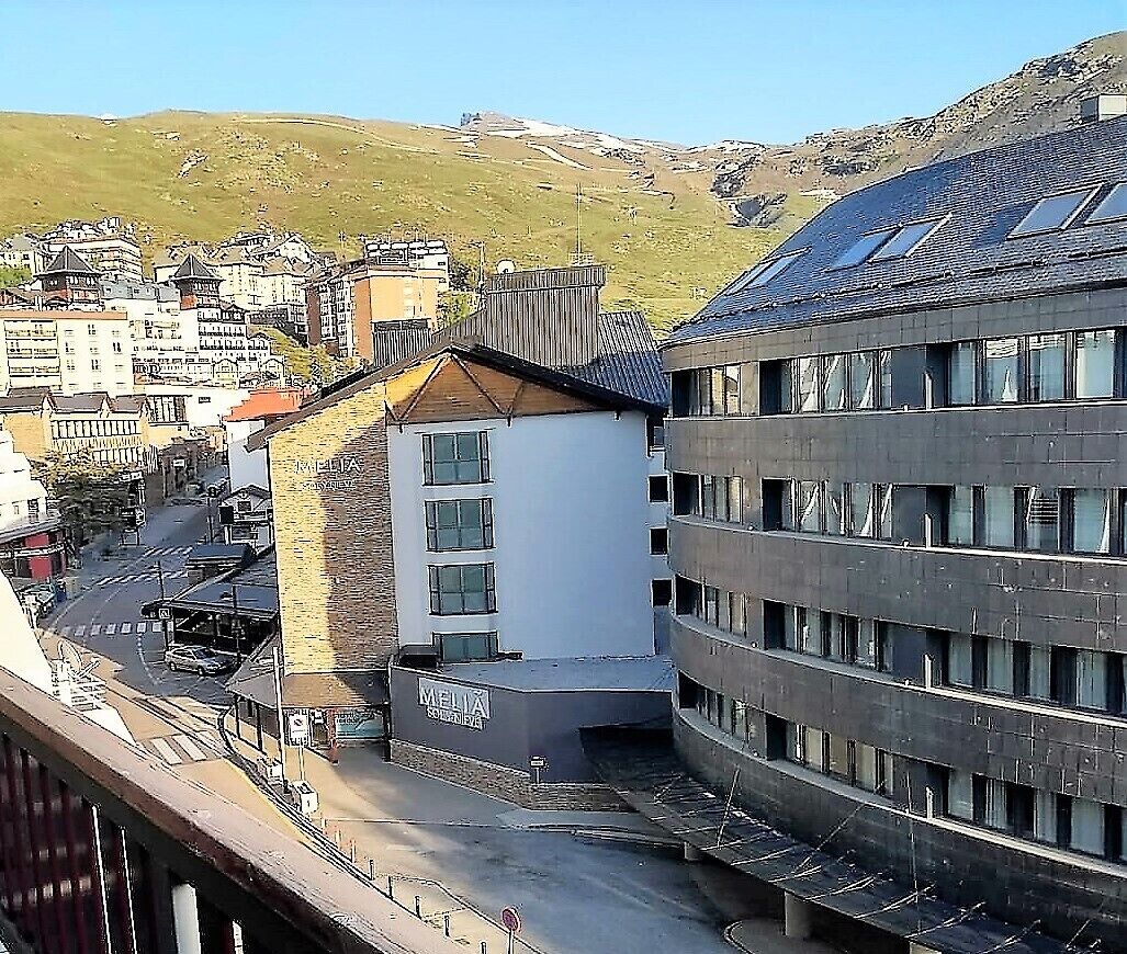 Un edificio de varios pisos con un estilo arquitectónico moderno, que presenta un techo plano y ventanas amplias.