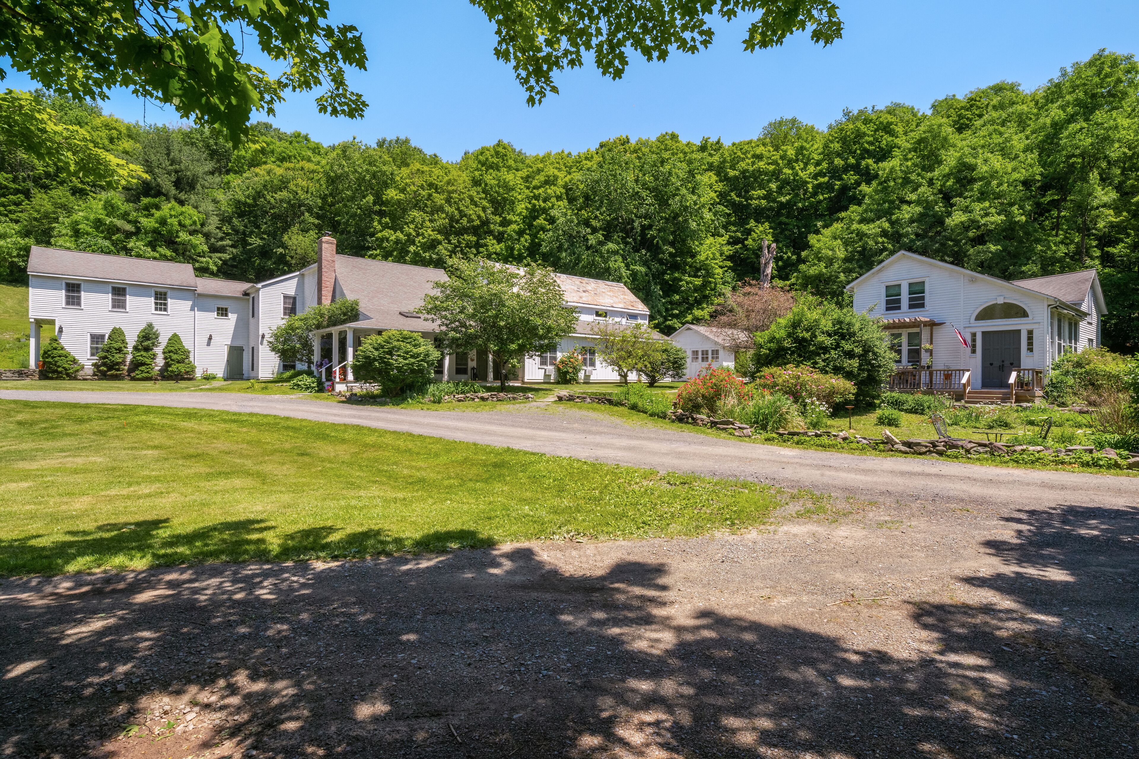 Un quartier résidentiel composé de plusieurs maisons, avec une allée gravillonnée et une pelouse bien entretenue.