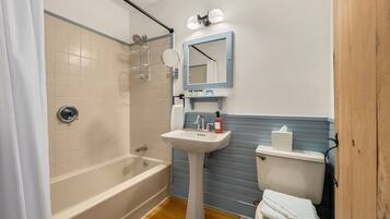 A bathroom with a bathtub, sink, and toilet.