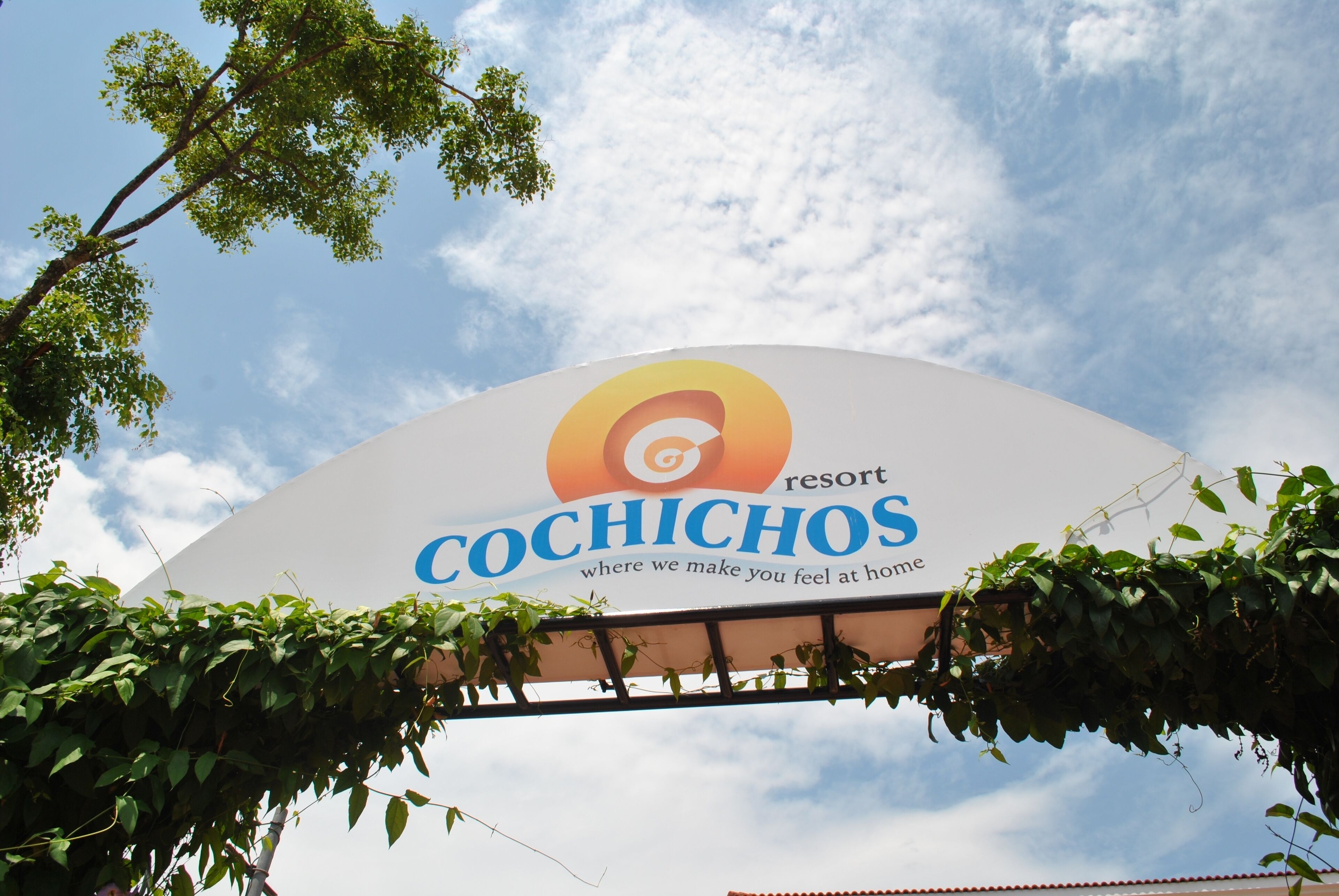 A sign for the Cochichos resort with a clear sky in the background.