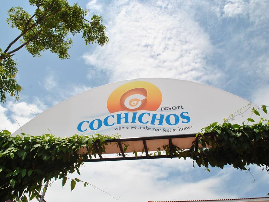 A sign for the Cochichos resort with a clear sky in the background.