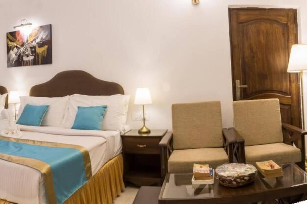 Une chambre d’hôtel avec deux lits, une chaise, une table et une porte.