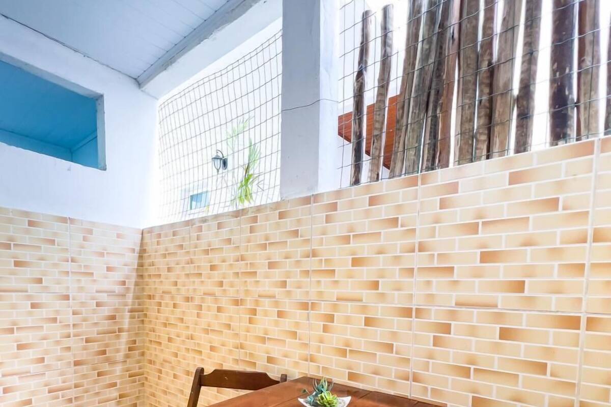 Un coin repas avec un mur en briques, une table en bois et des bancs.