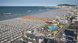 Une plage avec de nombreux parasols et beaucoup de monde.